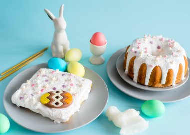 Paskalya tebrik kartı. Mavi arka planda Paskalya kompozisyonu. Paskalya pastası, labirent, çok renkli yumurtalar, kuzu şekeri, porselen tavşan, kilise mumları. Polonya Paskalyasının sembolleri