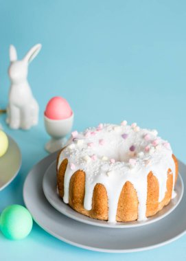 Lezzetli Paskalya pastaları ve yumurtalar, mavi arka planda Paskalya tavşanı. Minimum konsept. Boşluğu kopyala.