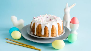 Pankart. Lezzetli Paskalya pastaları ve yumurtalar, mavi arka planda Paskalya tavşanı. Asgari konsept.