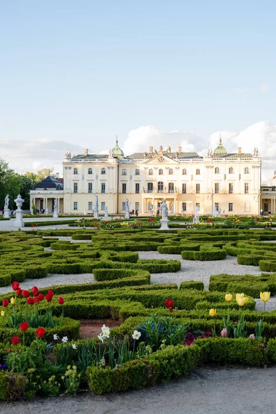 Baharda günbatımında Branicki Sarayı 'nın bahçelerine çiçek tarlaları, boxwood labirentleri, çeşmeler ve heykeller. : Polonya, Bialystok, Branicki Sarayı ve saraydaki bölge, Mayıs 2022.