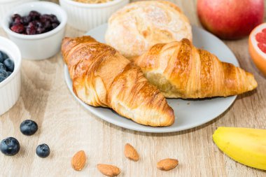 Sağlıklı kahvaltı. Kruvasan, çörek, süzme peynir, böğürtlen, meyve ve böğürtlen