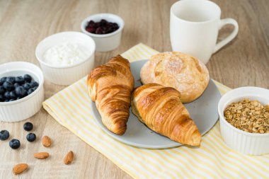 Sağlıklı kahvaltı. Kruvasan, çörek, süzme peynir, böğürtlen, meyve ve böğürtlen
