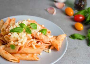 Fesleğen, peynir, sarımsak ve domatesli domates soslu makarna..