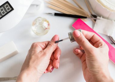 Tırnak manikürü. Güzel bir tırnak bakımı süreci. Kendine manikür yap. Yağ ile çivi ve tırnak bakımı. Yakın plan.