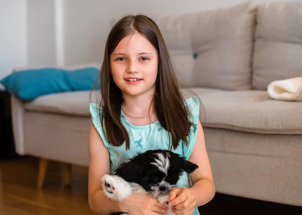 Child with dog at home. Little girl plays with a dog at home. Child and animal.