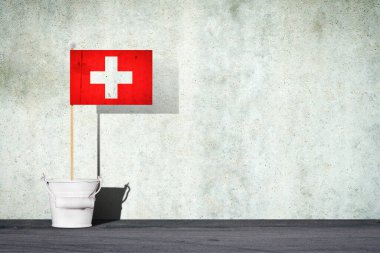 İsviçre bayrağı, bir çubuğun üzerinde, küçük bir kovanın içinde, beton bir duvarın arkasında. Uzayı kopyala İşaretler ve Semboller. 3 boyutlu illüstrasyon. Bayraklar.