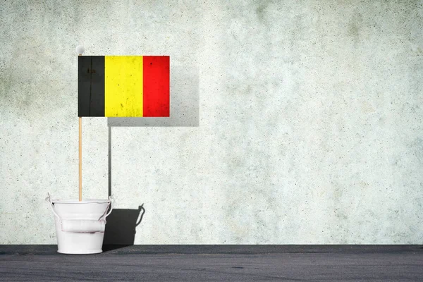 Flaga Belgii, na patyku, w małym wiadrze, na tle betonowej ściany. Odbiór. Znaki i symbole.Ilustracja 3D. — Zdjęcie stockowe