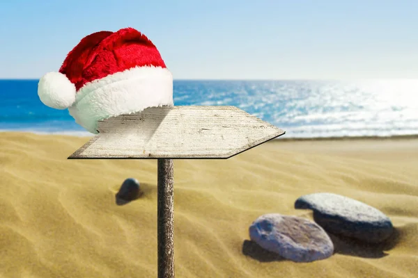 Wooden Sign Wearing Santa Claus Hat Backdrop Sand Dunes Ocean — Stockfoto