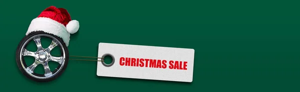 サンタクロースの帽子とクリスマスの販売で自動ホイール タグの単語は 緑の背景に オートショップ 自動修理店のためのバナーの概念 コピースペース テキストの場所 — ストック写真