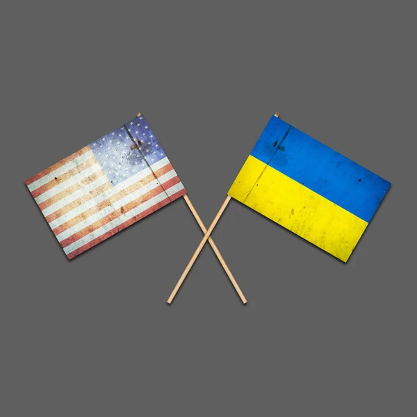 Vlajky Ameriky a Ukrajiny na dřevěných tyčích. Izolovaný na šedém pozadí. Mezinárodní politické vztahy. Společenství. Podpora. Politické ekonomické zázemí. — Stock fotografie