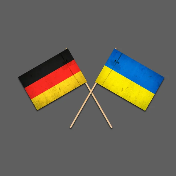木製の棒にドイツとウクライナの旗 灰色の背景に隔離されています 国際政治関係 共和国 支援だ 政治経済的背景 — ストック写真