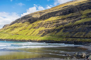 Güzel dağların ve deniz koyunun yanındaki yol. Faroe Adaları. Danimarka, Avrupa. Manzaralar. Doğa. Seyahat konsepti arka planı