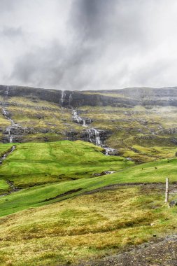 Güzel dağlardan çağlayan şelaleler. Faroe Adaları. Danimarka. Avrupa. Doğa Manzaraları