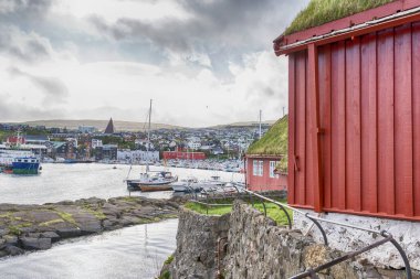 Faroe adaları. Danimarka. 11 Mayıs. 2022 yılı. Körfezde park edilmiş tekneler, güzel küçük renkli evlerin arasında. Avrupa. Nakliye. Su Taşımacılığı Doğa Manzaraları