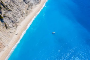 Lefkada, Yunanistan. Uzak beyaz Egremni plajı, İyon Denizi 'ndeki turkuaz renkli körfezde lüks bir yat teknesi var..
