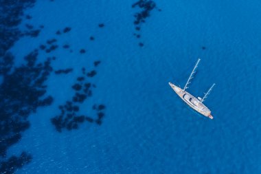 Lefkada, Yunanistan. Uzak beyaz Egremni plajı, İyon Denizi 'ndeki turkuaz renkli körfezde lüks bir yat teknesi var.