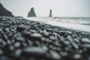 İzlanda 'da kasvetli bir günde kara bir sahilde taşlar