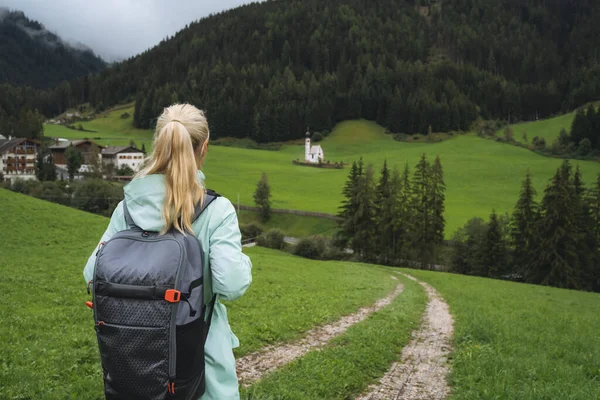 Mulher com mochila em trilha de caminhada para a igreja de St. Johann no vale de Val di Funes, Dolomitas, Itália, Europa — Fotografia de Stock