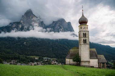 St. Valentine Kilisesi, Seis am Schlern, İtalya. Arkaplanda yağmur bulutları olan Schlern Dağı.