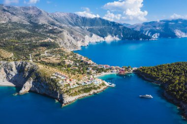 Assos, Yunanistan 'ın Kefalonia kentinin yukarısından güzel bir balıkçı köyü. Erial drone görüntüsü. Yelkenli tekneler turkuaz körfezde demirlemiş..