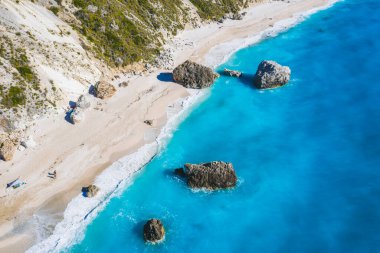 Turkuaz mavi İyon Denizi, Lefkada Adası, Yunanistan 'da büyük kaya parçalarıyla Kalamitsi sahilinin havadan görünüşü.