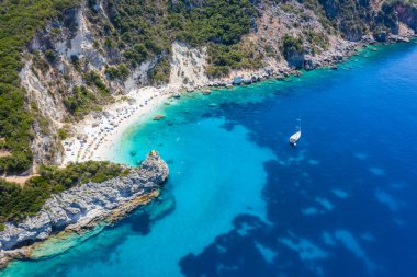 Vasiliki limanı yakınlarındaki Agiofili kumlu ikonik cennet kumlu sahilinin hava aracı fotoğrafı, zümrüt kristal berrak deniz ve yelkenli tekneler demirli, Lefkada Adası, İyonya, Yunanistan.