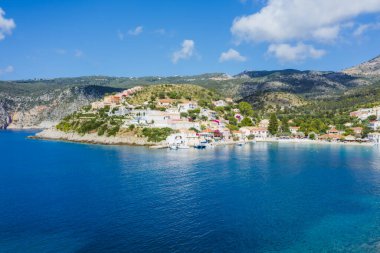 Assos, Yunanistan 'ın Kefalonia kentinin yukarısından güzel bir balıkçı köyü. Erial drone görüntüsü. Yelkenli tekneler turkuaz körfezde demirlemiş..