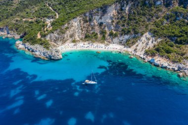 Vasiliki limanı yakınlarındaki Agiofili kumlu ikonik cennet kumlu sahilinin hava aracı fotoğrafı, zümrüt kristal berrak deniz ve yelkenli tekneler demirli, Lefkada Adası, İyonya, Yunanistan.