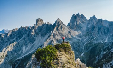 Ellerini havaya kaldırmış bir adamın havadan görünüşü destansı Cadini di Misurina dağ tepelerine, İtalyan Alplerine, Dolomitlere, İtalya 'ya, Avrupa' ya hayran hayran.