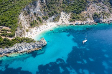 Vasiliki limanı yakınlarındaki Agiofili kumlu ikonik cennet kumlu sahilinin hava aracı fotoğrafı, zümrüt kristal berrak deniz ve yelkenli tekneler demirli, Lefkada Adası, İyonya, Yunanistan.
