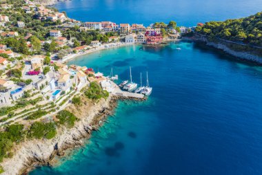 Assos, Yunanistan 'ın Kefalonia kentinin yukarısından güzel bir balıkçı köyü. Hava aracı görüntüsü. Yelkenli tekneler turkuaz körfezde demirlemiş..