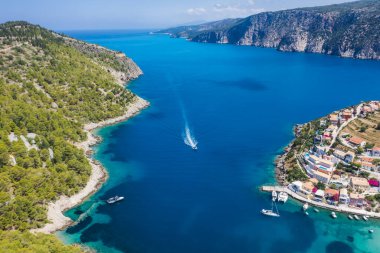 Assos, Yunanistan 'ın Kefalonia kentinin yukarısından güzel bir balıkçı köyü. Hava aracı görüntüsü. Yelkenli tekneler turkuaz körfezde demirlemiş..