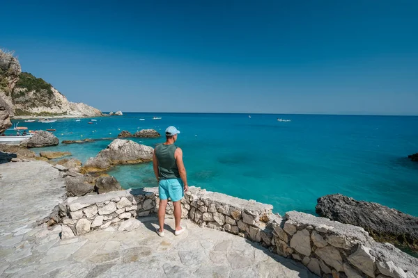 Yunanistan 'ın Lefkas İyon Adası' ndaki Agios Nikitas köyü yakınlarında kıyı şeridinin keyfini çıkaran bir turist görülüyor.