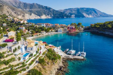 Assos, Yunanistan 'ın Kefalonia kentinin yukarısından güzel bir balıkçı köyü. Hava aracı görüntüsü. Yelkenli tekneler turkuaz körfezde demirlemiş..