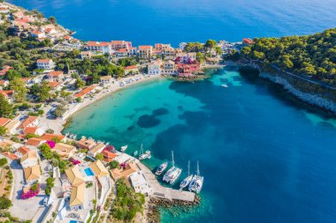 Assos, Yunanistan 'ın Kefalonia kentinin yukarısından güzel bir balıkçı köyü. Hava aracı görüntüsü. Yelkenli tekneler turkuaz körfezde demirlemiş..
