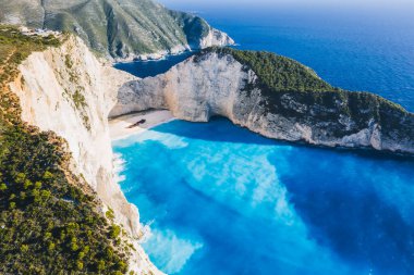 Yunanistan 'ın Zakynthos Adası' ndaki güzel Navagio ya da Batık Sahili 'nin hava manzarası. Uçurumun kenarındaki turistler yaz yolculuğunun tadını çıkarıyorlar..
