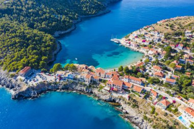 Assos, Yunanistan 'ın Kefalonia kentinin yukarısından güzel bir balıkçı köyü. Hava aracı görüntüsü. Yelkenli tekneler turkuaz körfezde demirlemiş..