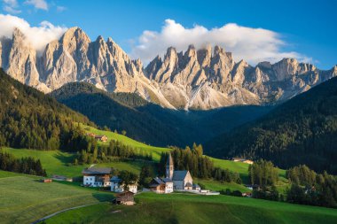 Val di Funes Vadisi 'ndeki St. Magdalena Kilisesi, Dolomitler, İtalya. Arkaplanda Furchetta ve Sass Rigais dağ zirveleri.