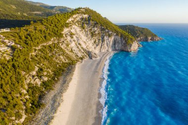Yunanistan 'ın Lefkada İyon adasındaki Agios Nikitas köyü yakınlarındaki Milos plajının hava manzarası. Akşam gün batımı Altın ışık.
