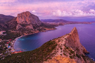 Sonbaharda Novyi Svit 'te pembe günbatımı ve arka planda Falcon Dağı. Sudak, Kırım Cumhuriyeti. Hava görünümü.