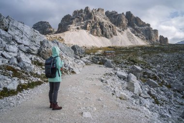 Sırt çantalı bir kadın Tre Cime Ulusal Parkı 'nda yürüyüş yapıyor. Dolomitler, İtalya, Avrupa.