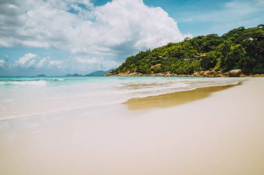 Seyşeller 'deki Mahe Adası' ndaki güzel kumlu küçük Anse plajı. Gökyüzünde devasa yağmurlu bulutlar. Tatil eğlencesi tatili.