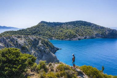 Yunanistan 'ın Cefalonia İyon adasındaki Assos köyüne yakın güzel ve pitoresk kayalık sahillerin uçurum kenarındaki insan gezginin havadan çekilmiş fotoğrafı..