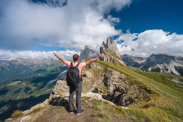 Sırt çantalı bir adam, Dolomite Alpleri, Odle dağları, Güney Tyrol, İtalya ve Avrupa 'daki Seceda zirvesinin keyfini çıkarırken ellerini kaldırdı. Seyahat tatili kavramı.