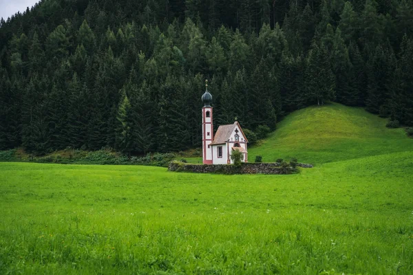 Val di Funes Vadisi 'ndeki St. Magdalena Kilisesi, Dolomitler, İtalya. Arkaplanda Furchetta ve Sass Rigais dağ zirveleri.