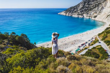 Myrtos Sahili 'nin tadını çıkaran şapkalı mutlu bir kadın. Sefalonya Adası, Yunanistan.