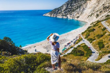 Myrtos Sahili 'nin tadını çıkaran şapkalı mutlu bir kadın. Sefalonya Adası, Yunanistan.
