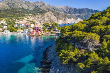 Assos, Yunanistan 'ın Kefalonia kentinin yukarısından güzel bir balıkçı köyü. Hava aracı görüntüsü. Yelkenli tekneler turkuaz körfezde demirlemiş..