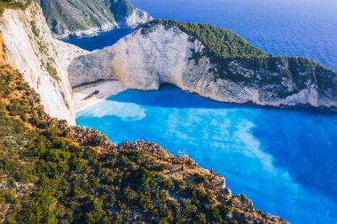 Yunanistan 'ın Zakynthos Adası' ndaki Navagio Sahili 'nin hava manzarası. Uçurumun kenarındaki turistler yaz yolculuğunun tadını çıkarıyorlar..