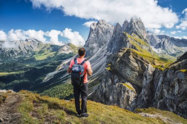 Sırt çantalı bir adam Dolomites Alpleri, Odle dağları, Güney Tyrol, İtalya ve Avrupa 'daki Seceda zirvesinin tadını çıkarıyor. Seyahat tatili kavramı.